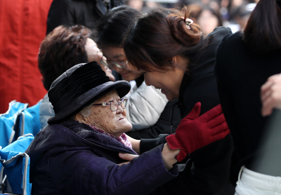 6일 서울 종로구 중학동 옛 일본대사관 앞에서 열린 ‘일본군 성노예제 문제 해결을 위한 제1412차 정기 수요시위’에서 생일을 맞은 이옥선(앞쪽), 이용수 할머니가 공연을 마친 참석자들을 안아주고 있다. 2019.11.6  연합뉴스