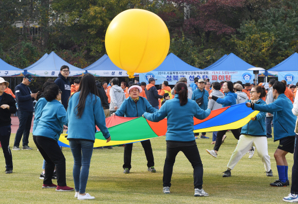 6일 서울 송파구 잠실종합운동장 보조경기장에서 열린 2019서울특별시장애인생활체육대회에서 참가 선수들이 낙하산공바운스 종목 대결을 펼치고 있다. 2019.11.6 오장환 기자 5zzang@seoul.co.kr