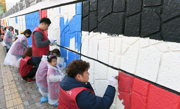 7일 ㈜에스엠면세점  임직원들이  인천공항점이 소재한  인천 중구 운서동에서 운서역 미관 개선을 위한 운서역 철도길 아래 웅벽에 벽화 그리기에 참여하고 있다. SM면세점의 사회공행사로 진행된 이번행사는 낙후된 웅벽을 아름다운 벽화로 탈바꿈시켜 지역 환경개선을 위한 활동이다. 2019. 11.07. 박지환 기자popocar@seoul.co.kr