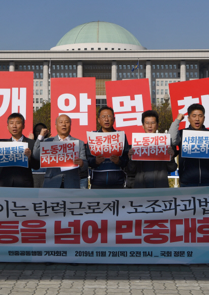7일 서울 국회앞에서 열린 탄력근로제 확대 저지 기자회견에 참석한 민주노총 조합원들이 피켓을 들고 있다. 2019.11.7 박지환기자 popocar@seoul.co.kr