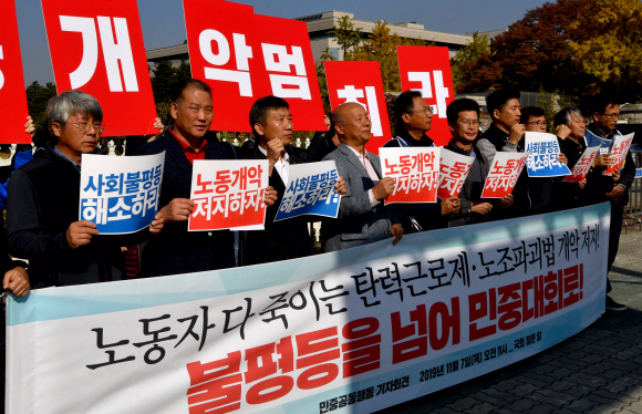 7일 서울 국회앞에서 열린 탄력근로제 확대 저지 기자회견에 참석한 민주노총 조합원들이 피켓을 들고 있다. 2019.11.7 박지환기자 popocar@seoul.co.kr