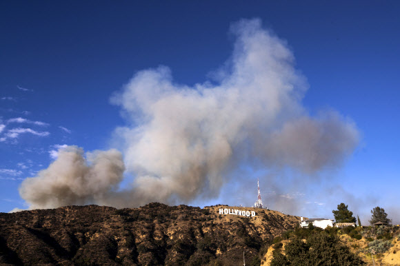9일(현지시간) 미국 캘리포니아주 로스앤젤레스의 할리우드 사인 뒤에서 발생한 바햄 화재로 연기가 피어오르고 있다. 최근 언론 보도에 따르면 화재는 25에이커를 태웠고 현재는 진압되고 있다. EPA 연합뉴스