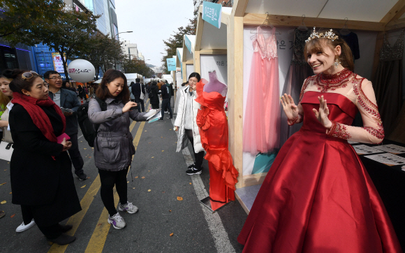 10일 서울 신촌에서 열린 소상공인한마당에서 드레스샵을 홍보하기 위해 드레스를 입은 한 외국인이 시민들의 시선을 끌고 있다. 2019. 11. 10 정연호 기자 tpgod@seoul.co.kr