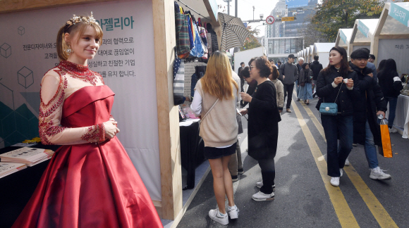 10일 서울 신촌에서 열린 소상공인한마당에서 드레스샵을 홍보하기 위해 드레스를 입은 한 외국인이 시민들의 시선을 끌고 있다. 2019. 11. 10 정연호 기자 tpgod@seoul.co.kr