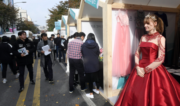 10일 서울 신촌에서 열린 소상공인한마당에서 드레스샵을 홍보하기 위해 드레스를 입은 한 외국인이 시민들의 시선을 끌고 있다. 2019. 11. 10 정연호 기자 tpgod@seoul.co.kr