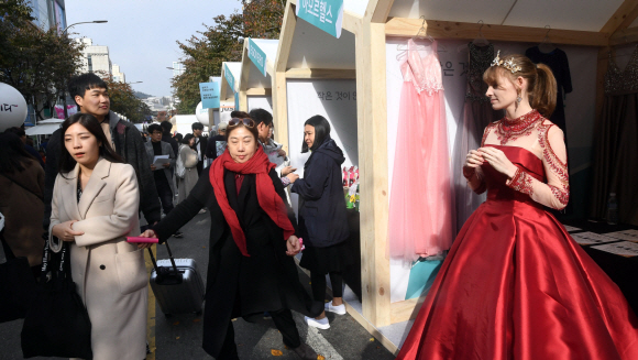 10일 서울 신촌에서 열린 소상공인한마당에서 드레스샵을 홍보하기 위해 드레스를 입은 한 외국인이 시민들의 시선을 끌고 있다. 2019. 11. 10 정연호 기자 tpgod@seoul.co.kr