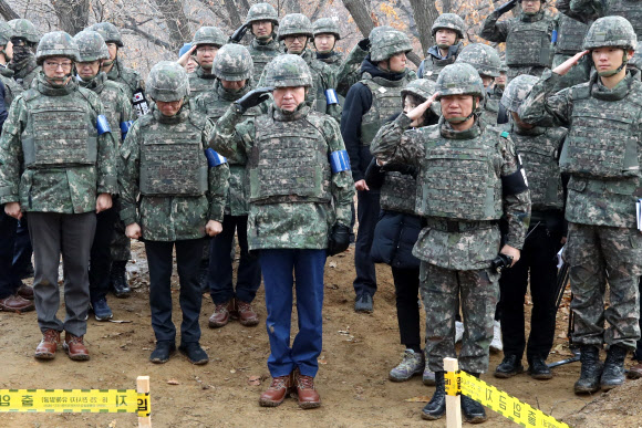 이낙연 국무총리가 15일 오전 강원도 철원 화살머리고지 내 6·25 전사자 유해발굴 현장을 방문해 발굴된 유해에 헌화한 뒤 경례하고 있다. 2019.11.15  연합뉴스