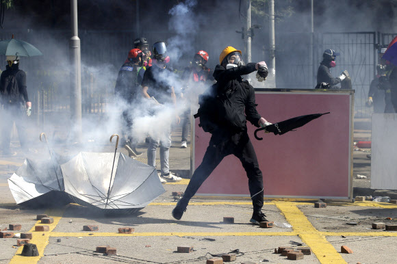 17일(현지시간) 홍콩 폴리테크닉대학교 캠퍼스에서 경찰과 시위대가 최루탄과 화염병을 주고받으며 충돌했다. AP 연합뉴스