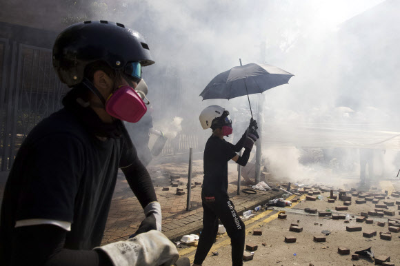 17일(현지시간) 홍콩 폴리테크닉대학교 캠퍼스에서 경찰과 시위대가 최루탄과 화염병을 주고받으며 충돌했다. AP 연합뉴스