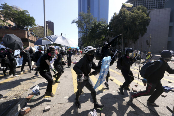 17일(현지시간) 홍콩 폴리테크닉대학교 캠퍼스에서 경찰과 시위대가 최루탄과 화염병을 주고받으며 충돌했다. AP 연합뉴스