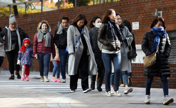 휴일부터 내리던 비가 그치고 쌀쌀한 날씨를 보인 18일 서울 중구 명동에서 관광객들이 두터운 외투와 방한용품을 착용하고 길을 걷고 있다. 2019. 11. 18 박윤슬 기자 seul@seoul.co.k