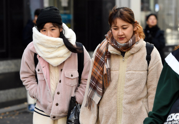 휴일부터 내리던 비가 그치고 쌀쌀한 날씨를 보인 18일 서울 중구 명동에서 관광객들이 두터운 외투와 방한용품을 착용하고 길을 걷고 있다. 2019. 11. 18 박윤슬 기자 seul@seoul.co.k