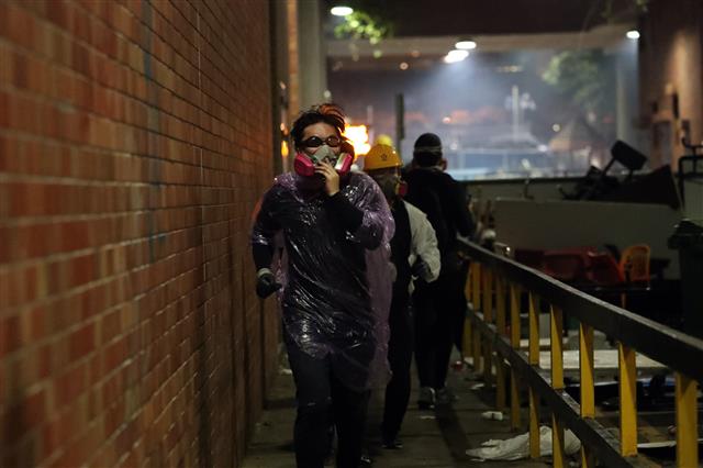 18일 오전 홍콩 이공대학교에서 학생들이 경찰을 피해 도망가고 있다. 2019.11.18 뉴스1