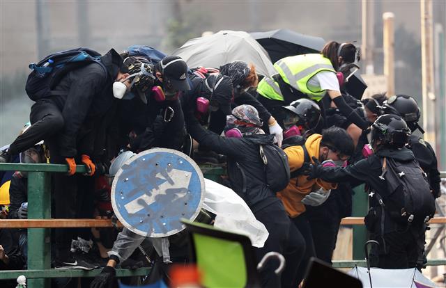 18일 오후 홍콩 이공대학교에서 학생들이 경찰의 진압작전을 피해 도망가고 있다. 2019.11.18 뉴스1
