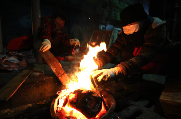 전국적으로 기온이 큰 폭으로 내린 19일 오전 경남 창원시 마산합포구 한 시장에서 상인들이 모닥불을 피워놓고 불을 쬐며 손을 녹이고 있다. 2019.11.19  연합뉴스