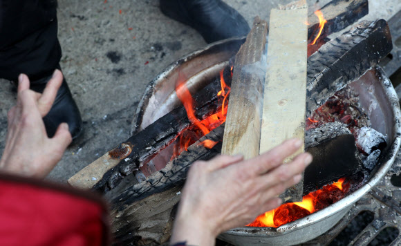 강원 전역에 한파주의보가 발효 중인 19일 오전 춘천시 번개시장에서 상인들이 모닥불에 손을 녹이고 있다. 2019.11.19  연합뉴스