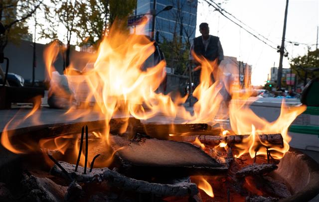 중부지방에 한파특보가 발효된 19일 서울 중구 중림시장에서 상인들이 모닥불을 쬐고 있다. 2019.11.19 뉴스1
