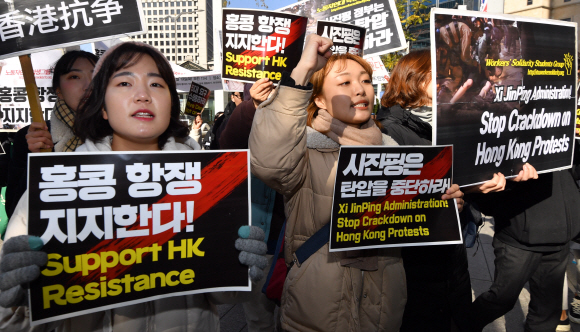 17일 서울 명동 중국대사관 앞에서 열린 홍콩민주 항쟁 지지, 시진핑정부의 홍콩탄압 중단을 촉구하는 기자회견에 참석한 청년 학생과 유학생들이 행진을 하며 구호를 외치고 있다. 2019.11.19 박지환기자 popocar@seoul.co.kr