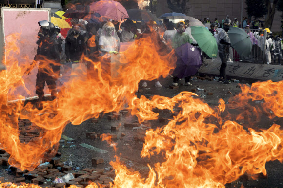 17일 홍콩 이공대에서 경찰의 진압에 맞선 시위대가 화염병으로 불타고 있는 바닥을 바라보고 있다. 2019.11.17  AP 연합뉴스