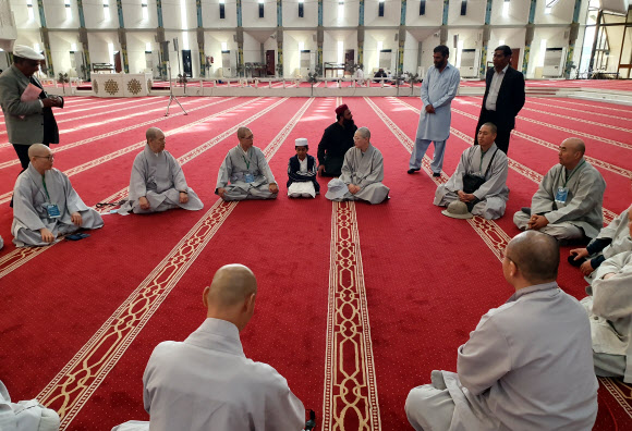 스님들 사이에 앉아 코란 암송하는 이슬람 학생