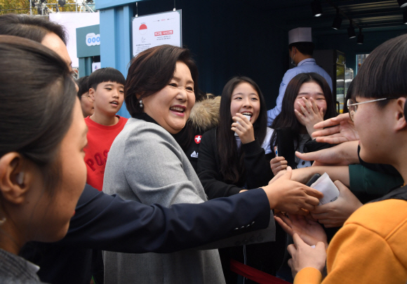 22일 문재인대통령 부인 김정숙여사가 부산 전포동 놀이마루에서 열리는 D-3 한 아세안 푸드스트리트 ‘아세안의 맛’ 행사에 참석해 행사장을 찾은 학생들과 인사하고 있다. . 2019.11.22 청와대사진기자단 / 한국일보 류효진