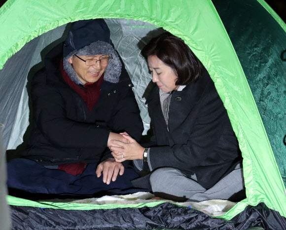 자유한국당 나경원 원내대표가 23일 오전 미국에서 돌아온 뒤 청와대 앞 분수대 광장을 찾아 단식투쟁 나흘째를 맞이한 황교안 대표의 손을 꼭 잡아주고 있다. 2019.11.23  연합뉴스