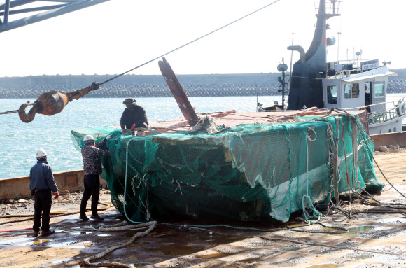 23일 제주시 대정읍 화순항에 도착한 인양 바지선 위에 대성호 선미가 그물에 싸인 채 놓여 있다. 2019.11.23  연합뉴스