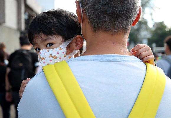 23일 오전 홍콩 카오룽역 인근에서 열린 최루탄 사용 반대 집회에 참가한 한 어린이가 아빠 품에 안겨 행진하고 있다. 2019.11.23  연합뉴스