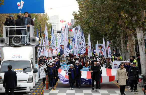 우리공화당 당원들과 태극기부대 참가자들이 23일 경기도 의정부역 앞 도로에서 제156차 태극기 집회를 마친 후 경기도북부청 앞까지 3㎞가량 가두행진을 벌이고 있다.  2019.11.23  연합뉴스