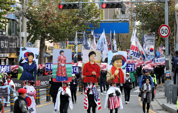우리공화당 당원들과 태극기부대 참가자들이 23일 경기도 의정부역 앞 도로에서 제156차 태극기 집회를 마친 후 경기도북부청 앞까지 3㎞가량 가두행진을 벌이고 있다. 2019.11.23  연합뉴스
