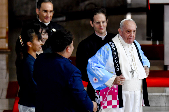 프란치스코 로마 가톨릭 교황이 일본 방문 사흘째인 25일(현지시간) 일본 도쿄 성 메리 성당을 방문해 전통 셔츠를 선물받아 입고 포즈를 취하고 있다. 교황이 일본 왕궁을 찾은 것은 1981년 요한 바오로 2세 교황의 방일 때에 이어 38년 만이다. EPA 연합뉴스