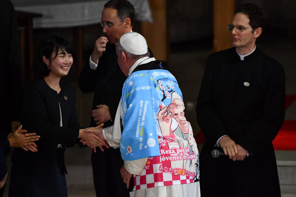 프란치스코 로마 가톨릭 교황이 일본 방문 사흘째인 25일(현지시간) 도쿄 성 메리 성당을 방문해 전통 셔츠를 선물받아 입어보고 인사를 하고 있다. 교황이 일본 왕궁을 찾은 것은 1981년 요한 바오로 2세 교황의 방일 때에 이어 38년 만이다. AFP 연합뉴스