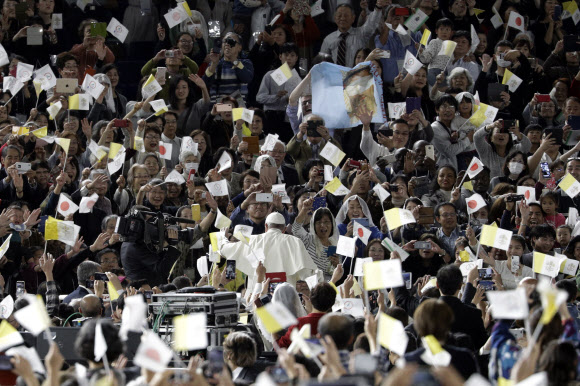 프란치스코 로마 가톨릭 교황이 일본 방문 사흘째인 25일(현지시간) 도쿄 돔에서 열린 미사에 차를 타고 들어서자 신도들이 환호하고 있다. 교황이 일본 왕궁을 찾은 것은 1981년 요한 바오로 2세 교황의 방일 때에 이어 38년 만이다. AP 연합뉴스