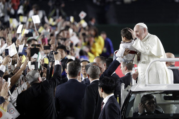 프란치스코 로마 가톨릭 교황이 일본 방문 사흘째인 25일(현지시간) 도쿄 돔에서 열린 미사에 차를 타고 들어서며 아이에게 축복 하고 있다. 교황이 일본 왕궁을 찾은 것은 1981년 요한 바오로 2세 교황의 방일 때에 이어 38년 만이다. AP 연합뉴스