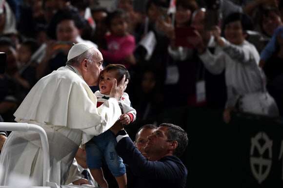 프란치스코 로마 가톨릭 교황이 일본 방문 사흘째인 25일(현지시간) 도쿄 돔에서 열린 미사에 차를 타고 들어서며 아이에게 축복의 키스를 하고 있다. 교황이 일본 왕궁을 찾은 것은 1981년 요한 바오로 2세 교황의 방일 때에 이어 38년 만이다. AFP 연합뉴스
