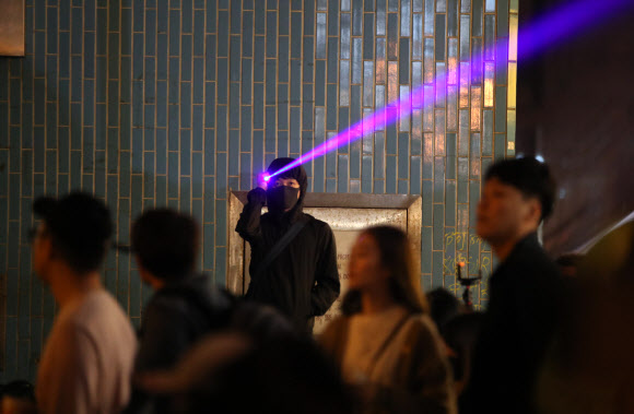 26일 오전 홍콩 이공대학 앞에서 한 시위 참가자가 경찰들을 향해 레이저 불빛을 비추고 있다. 2019.11.26  연합뉴스