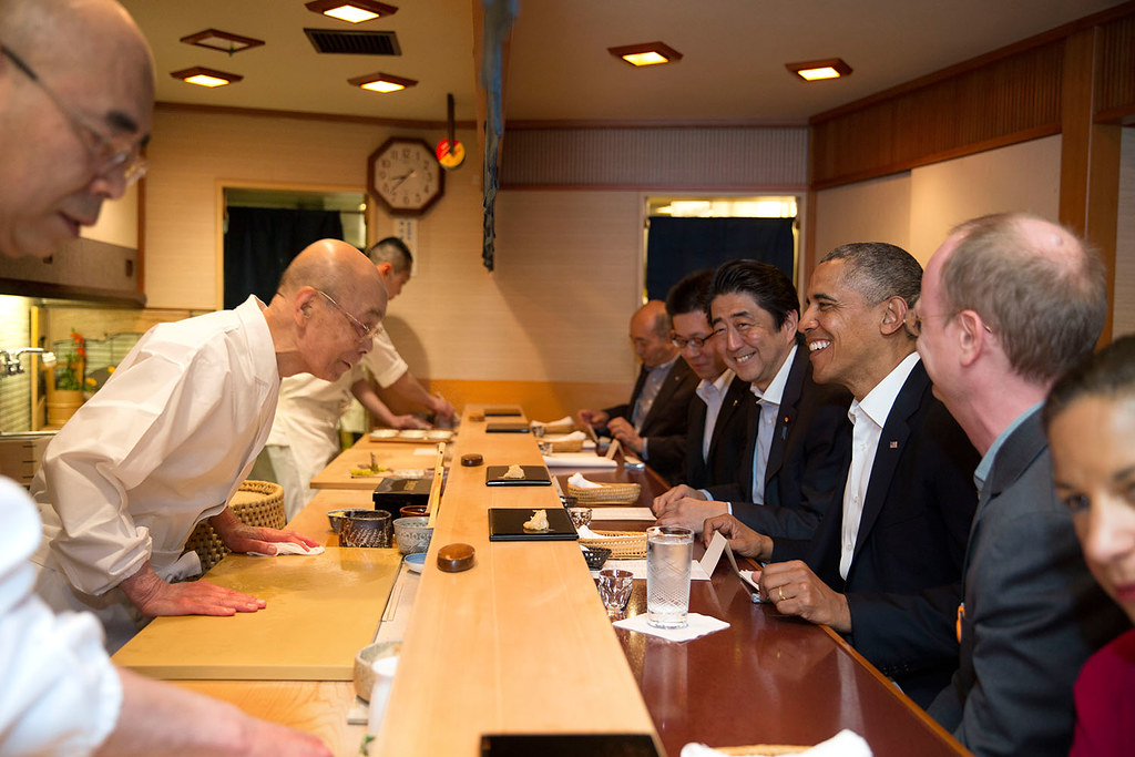 2014년 4월 일본을 방문한 버락 오바마(오른쪽 세 번째) 미국 대통령과 아베 신조(네 번째) 일본 총리가 도쿄 긴자에 있는 고급 초밥집 스키야바시 지로를 방문해, 초밥 장인 오노 지로(왼쪽 두 번째)의 인사를 받고 있다. 플리커 오바마 행정부 페이지 제공