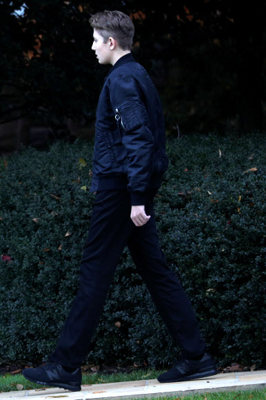 도널드 트럼프 미국 대통령의 아들인 배런 트럼프가 26일(현지시간) 미국 워싱턴 백악관 집무실에서 ‘마린원’까지 대통령 부부와 함께 걷고 있다. 로이터 연합뉴스