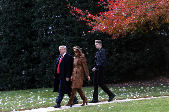 도널드 트럼프 미국 대통령과 멜라니아 트럼프 여사, 아들인 배런 트럼프가 26일(현지시간) 미국 워싱턴 백악관 집무실에서 ‘마린원’까지 걷고 있다. 로이터 연합뉴스