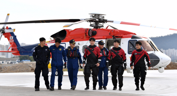해상구조훈련을 마친 응급구조사 나동수 순경과 항공정비사 노현우 경장을 비롯한 항공대원들이 밝은 표정으로 격납고로 복귀하고 있다.