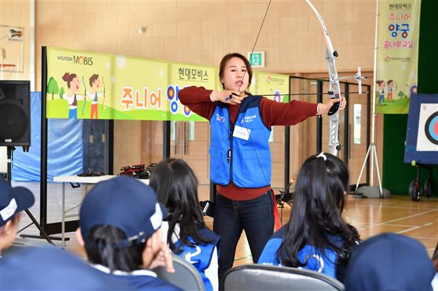 2008년 베이징 올림픽 여자 양궁 단체전 금메달리스트인 주현정 선수가 현대모비스가 운영하는 ‘주니어 양궁 꿈나무 교실’에 참여한 초등학생들에게 활 쏘는 법을 가르치고 있다.  현대모비스 제공
