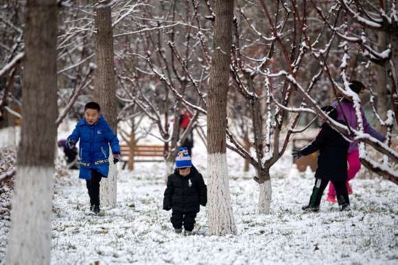 어린이들이 30일(현지시간) 중국 베이징의 한 공원에서 쌓인 눈을 밟으며 즐거운 시간을 보내고 있다. AFP 연합뉴스