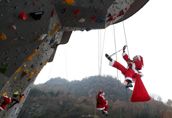 1일 서울 용마산 인공암장에서 산타복을 입은 암벽 산악회 ‘쌩곰등반클럽’ 회원들이 구세군 자선냄비 행사 발대식에서 포즈를 취하고 있다.  박창용 쌩곰등반클럽회장과 산악회원들은 12월 말까지 매주 토, 일요일 8회에 걸쳐 북한산 일대에서 자선모금 캠페인을 할 계획이다. 2019.12.1  연합뉴스