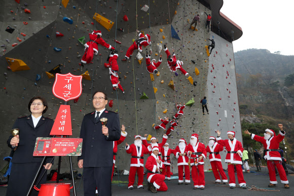 1일 서울 용마산 인공암장에서 산타복을 입은 암벽 산악회 ‘쌩곰등반클럽’ 회원들과 구세군 자선냄비본부 곽창희 사무총장(오른쪽) 등이 구세군 자선냄비 행사 발대식에서 포즈를 취하고 있다.  박창용 쌩곰등반클럽회장과 산악회원들은 12월 말까지 매주 토, 일요일 8회에 걸쳐 북한산 일대에서 자선모금 캠페인을 할 계획이다. 2019.12.1  연합뉴스