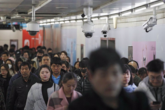 지난 2월 중국 베이징의 한 지하철역을 이용하는 승객들 머리 위 천장에 수많은 감시 카메라가 매달려 있다. AP 연합뉴스