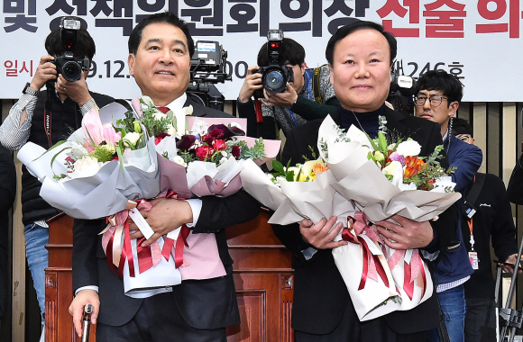 자유한국당 신임 원내대표에 선출된 심재철 의원(왼쪽)과 새 정책위의장에 선출된 김재원 의원이 9일 오전 국회에서 열린 의원총회에서 축하 꽃다발을 받고 기뻐하고 있다. 2019. 12.9. 김명국 선임기자 daunso@seoul.co.kr