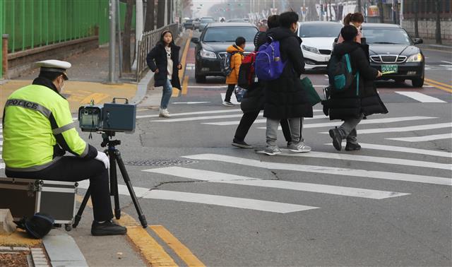 대전 서구 둔산초등학교 앞 어린이보호구역(스쿨존)에서 경찰관(왼쪽)이 과속 단속 카메라를 이용해 차량 속도를 감시하고 있다. 뉴스1