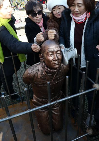 신군부가 일으킨 12·12 군사반란 40주년인 12일 5·18 관련 단체 회원들이 서울 광화문광장에서 전두환 전 대통령의 구속 수사를 촉구하는 기자회견을 한 뒤 이를 상징적으로 표현하기 위해 제작한 동상 조형물을 때리는 퍼포먼스를 하고 있다. 2019.12.12  연합뉴스