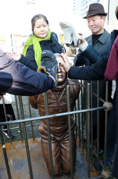 신군부가 일으킨 12·12 군사반란 40주년인 12일 5·18 관련 단체 회원들이 서울 광화문광장에서 전두환 전 대통령의 구속 수사를 촉구하는 기자회견을 한 뒤 이를 상징적으로 표현하기 위해 제작한 동상 조형물을 때리는 퍼포먼스를 하고 있다. 2019.12.12  연합뉴스