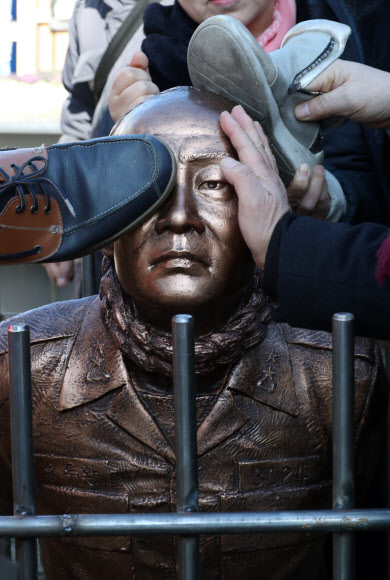 신군부가 일으킨 12·12 군사반란 40주년인 12일 5·18 관련 단체 회원들이 서울 광화문광장에서 전두환 전 대통령의 구속 수사를 촉구하는 기자회견을 한 뒤 이를 상징적으로 표현하기 위해 제작한 동상 조형물을 때리는 퍼포먼스를 하고 있다. 2019.12.12  연합뉴스